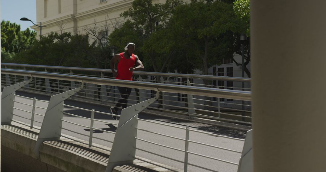 Man jogging on urban bridge during sunny day - Free Images, Stock Photos and Pictures on Pikwizard.com