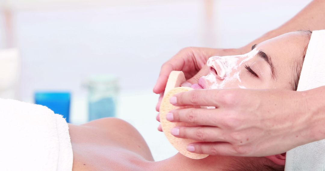 A young Caucasian woman is receiving a facial treatment from a beautician, with copy space - Free Images, Stock Photos and Pictures on Pikwizard.com