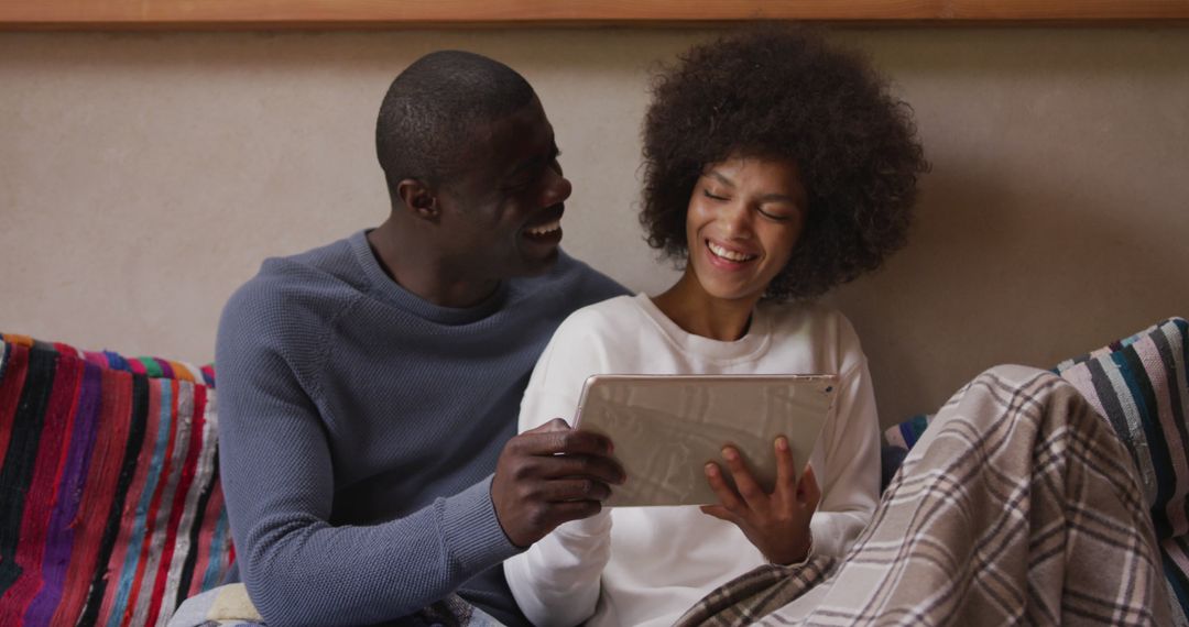 Happy Couple Relaxing on Couch Using Tablet Together
