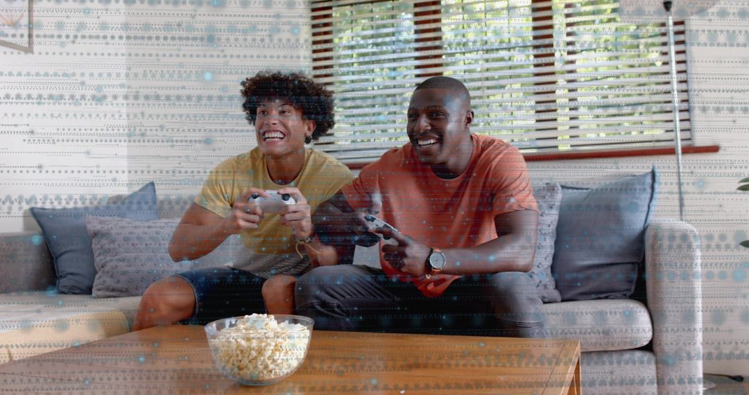 Playing competitive couch gaming in sunlit living room with controllers and popcorn