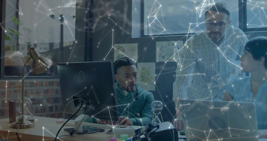 Diverse team collaborating around laptop in open-plan office with digital network overlay