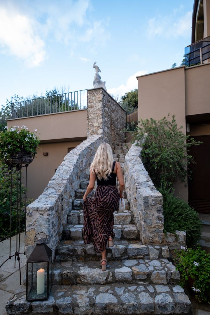 Woman in Stylish Dress Ascending Stone Staircase Outdoors