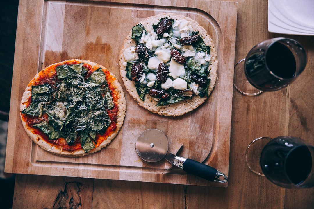 Gourmet Homemade Pizzas with Red Wine on Rustic Wooden Table