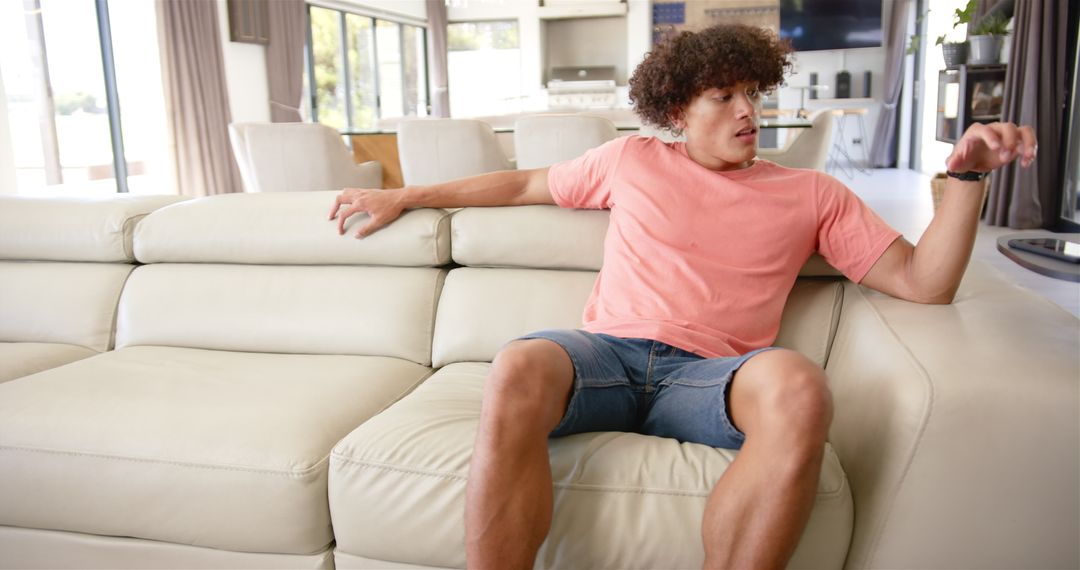 Man Relaxing on Sofa in Modern Living Room Looking Surprised
