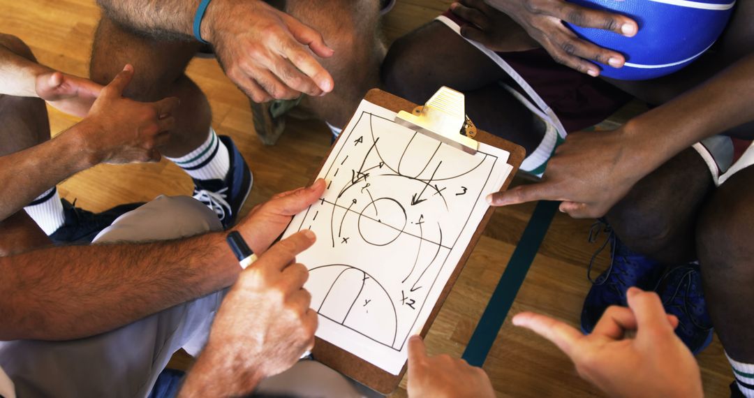 Baskeball Team Discussing Strategy on Clipboard During Game Huddle