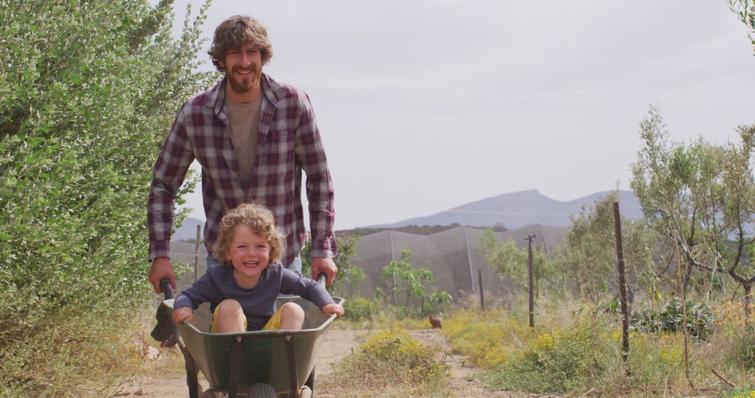 Father Enjoying Wheelbarrow Ride with Happy Child in Countryside - Free Images, Stock Photos and Pictures on Pikwizard.com