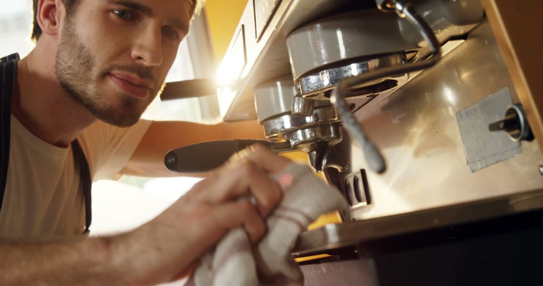 Barista Maintaining Coffee Machine in Café Kitchen