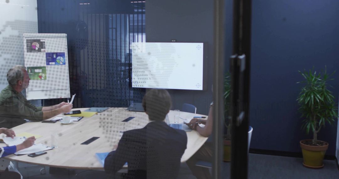 Business Team Collaborating in Glass-Walled Boardroom During Strategy Presentation
