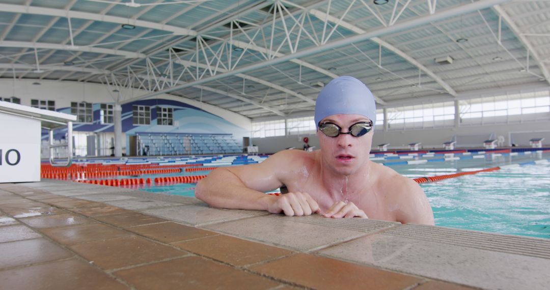 Male swimmer resting at edge of indoor pool after workout - Free Images, Stock Photos and Pictures on Pikwizard.com