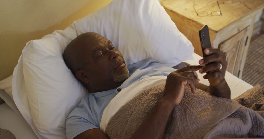 Mature Man Relaxing in Bed Browsing Smartphone - Free Images, Stock Photos and Pictures on Pikwizard.com