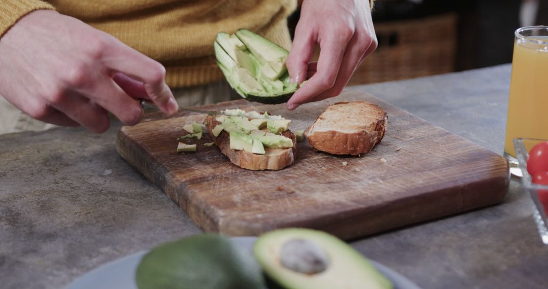 Person Slicing Avocado on Wooden Cutting Board for Breakfast - Free Images, Stock Photos and Pictures on Pikwizard.com