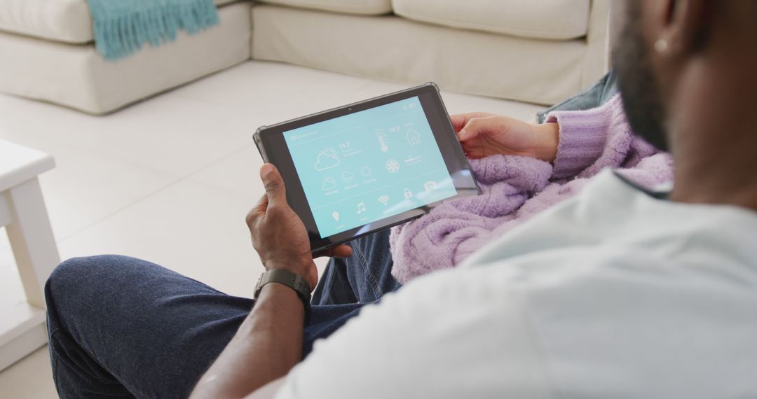 Man Using Tablet for Home Automation on Sofa - Free Images, Stock Photos and Pictures on Pikwizard.com