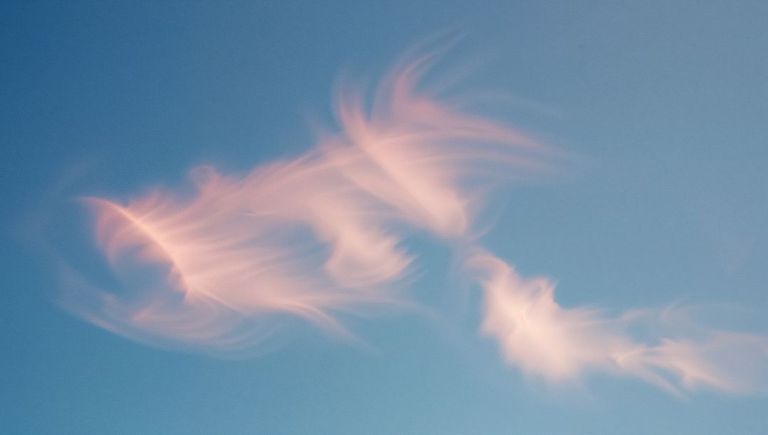 Ethereal Cirrus Clouds Floating Across Clear Blue Sky