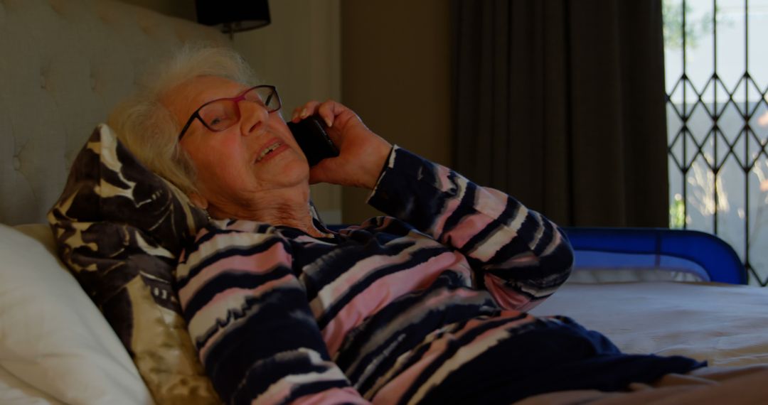 Elderly Woman Relaxing on Bed Talking on Phone - Free Images, Stock Photos and Pictures on Pikwizard.com