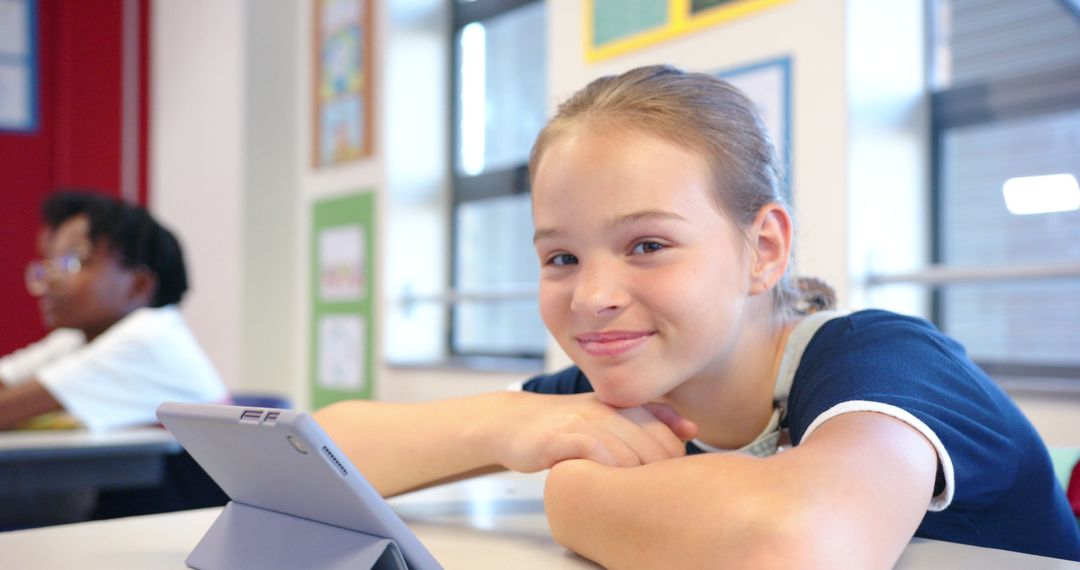 Smiling Preteen Girl Using Tablet in Vibrant Classroom