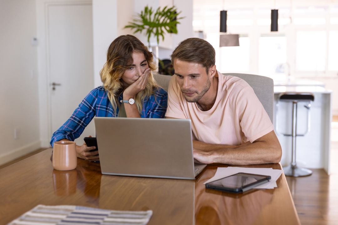 Couple Collaborating at Home with Laptop and Smartphone
