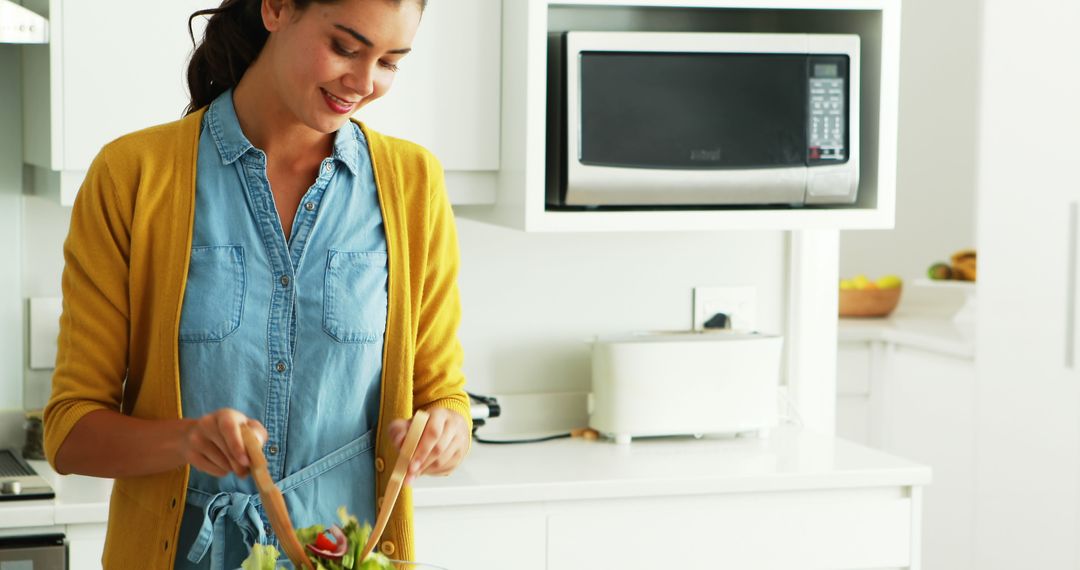 Smiling Woman Preparing Salad in Modern Kitchen with Microwave - Free Images, Stock Photos and Pictures on Pikwizard.com