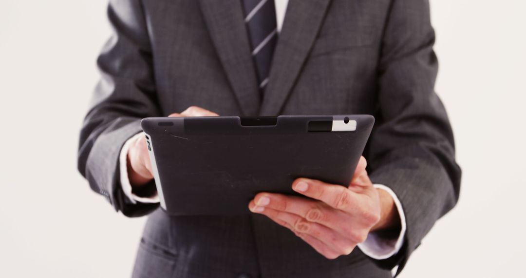 Businessman Using Digital Tablet in Formal Suit - Free Images, Stock Photos and Pictures on Pikwizard.com