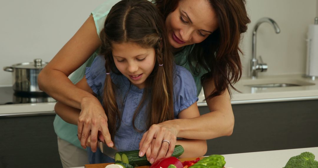 Mother Teaching Daughter to Chop Vegetables in Modern Kitchen - Free Images, Stock Photos and Pictures on Pikwizard.com