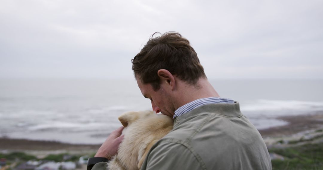 Man Embracing Dog on Sea Cliff, Reflecting Love and Nature - Free Images, Stock Photos and Pictures on Pikwizard.com