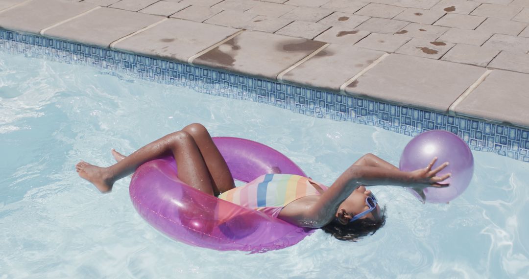 Child Relaxing on Inflatable Ring with Ball in Swimming Pool - Free Images, Stock Photos and Pictures on Pikwizard.com