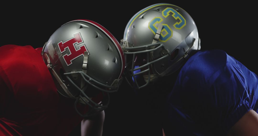 Two Football Players in Helmets Facing Each Other in Intense Competition - Free Images, Stock Photos and Pictures on Pikwizard.com