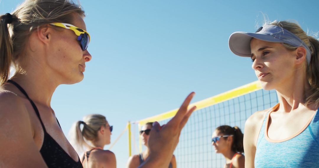 Women Engaging in Beach Volleyball Discussion Under Clear Sky - Free Images, Stock Photos and Pictures on Pikwizard.com