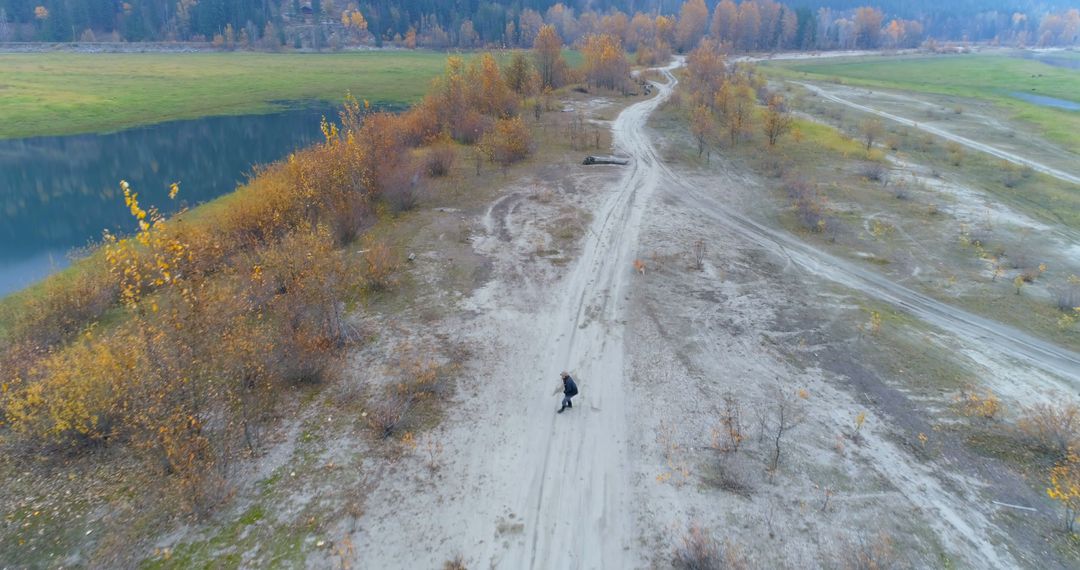 Aerial View of Man Walking on Dirt Road in Autumn Landscape - Free Images, Stock Photos and Pictures on Pikwizard.com