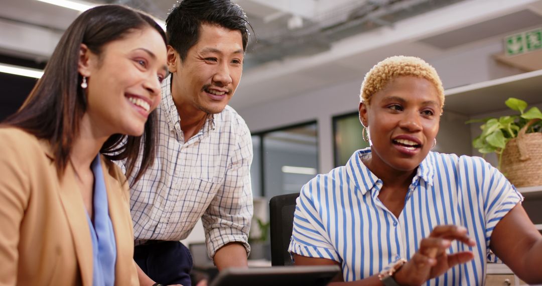 Diverse Colleagues Collaborating on Digital Project in Office