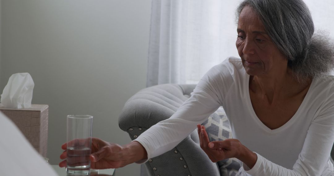 Concerned Elderly Woman Reaching for Glass of Water at Home - Free Images, Stock Photos and Pictures on Pikwizard.com