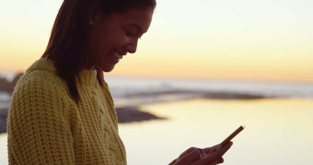 Woman Using Smartphone by Beach at Sunset - Free Images, Stock Photos and Pictures on Pikwizard.com