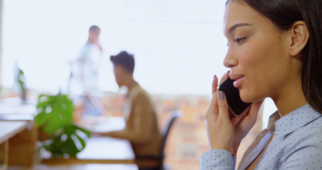 Businesswoman Talking on Phone in Modern Open Office - Free Images, Stock Photos and Pictures on Pikwizard.com