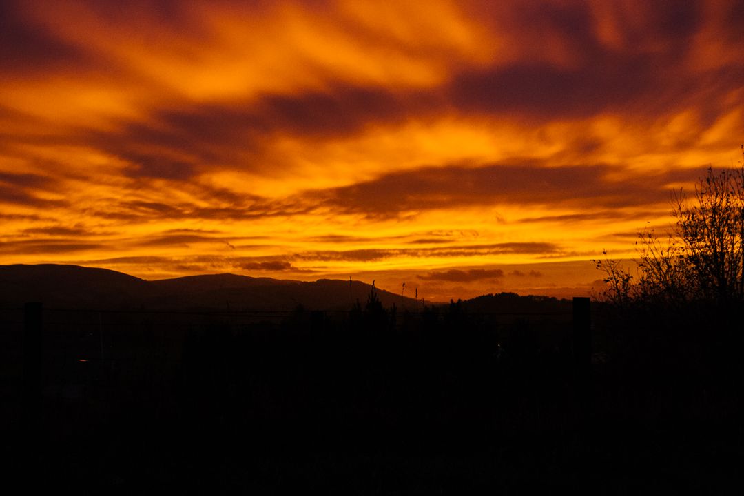 Vivid Orange Sunset Over Silhouetted Mountains - Free Images, Stock Photos and Pictures on Pikwizard.com