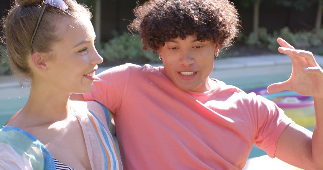 Friends Sitting by Pool Chatting and Enjoying Sunny Day
