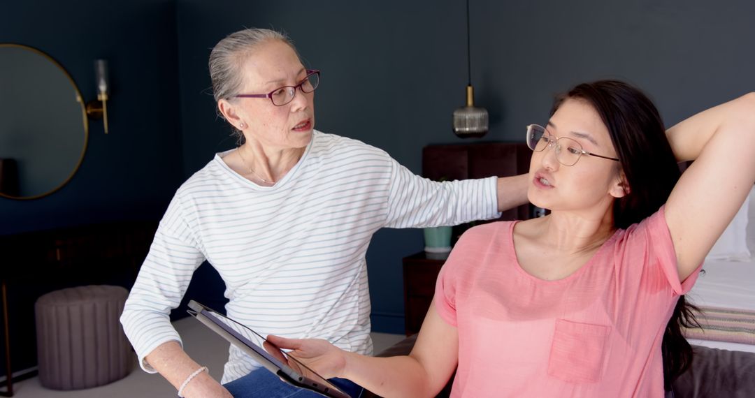 Senior Asian Mother Mentoring Daughter in Relaxation Routine