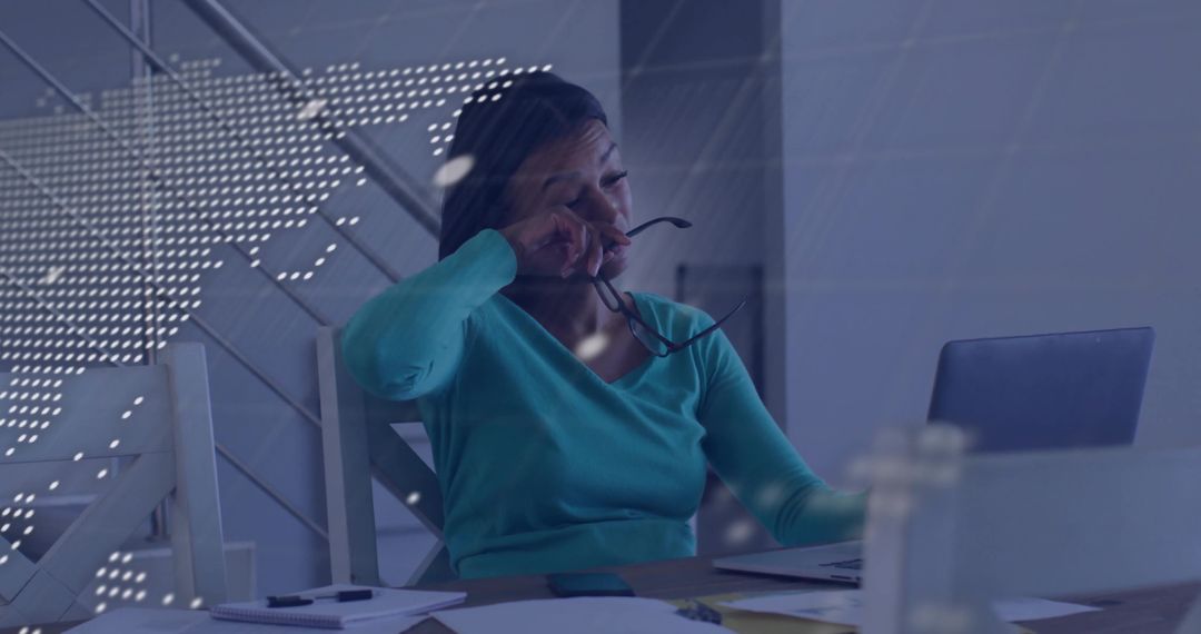 Exhausted Professional Woman at Workspace Adjusts Glasses