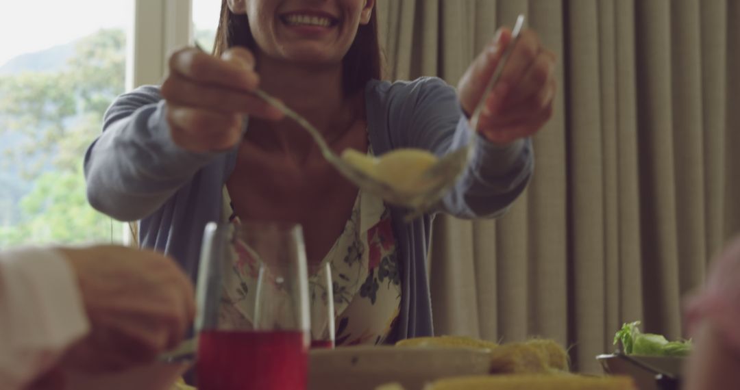 Smiling Woman Serving Family Meal at Home Gathering - Free Images, Stock Photos and Pictures on Pikwizard.com