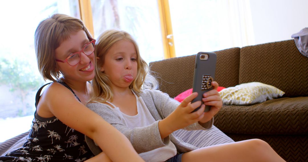 Sisters Sharing Fun Moments While Taking Selfie Together at Home - Free Images, Stock Photos and Pictures on Pikwizard.com