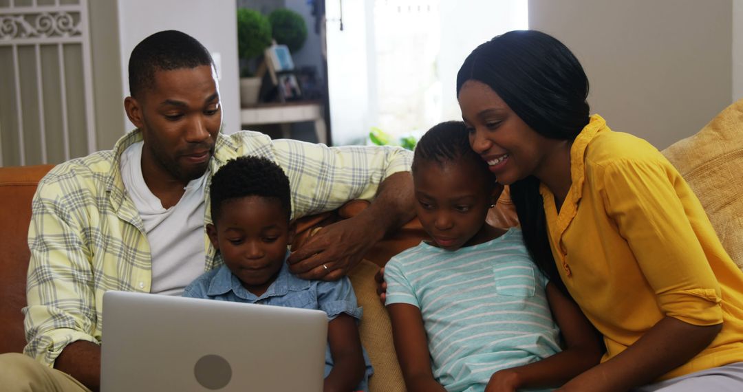 Happy African American Family Watching Something on Laptop Together at Home - Free Images, Stock Photos and Pictures on Pikwizard.com