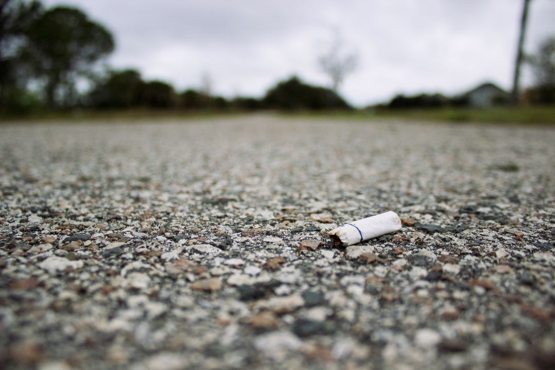 Discarded Cigarette Butt on Rural Asphalt Road - Free Images, Stock Photos and Pictures on Pikwizard.com