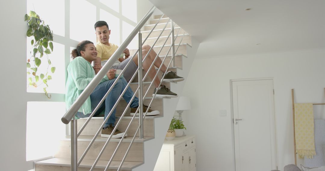 Happy Young Couple Relaxing on Staircase in Modern Home - Free Images, Stock Photos and Pictures on Pikwizard.com