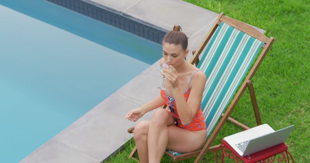 Young Woman in Swimsuit Relaxing by Poolside with a Drink and Laptop - Free Images, Stock Photos and Pictures on Pikwizard.com