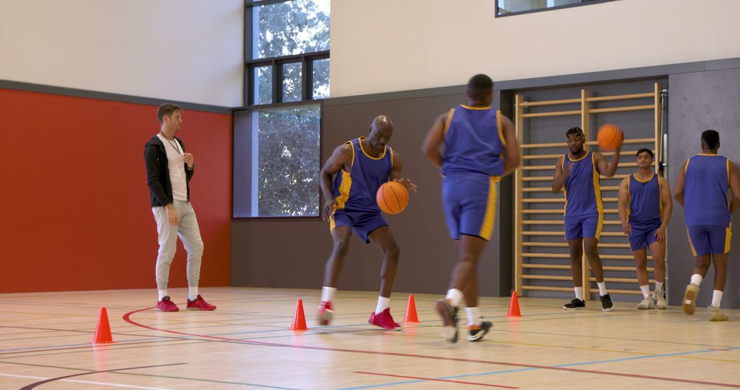 Basketball Players Dribbling Through Cones in Gym