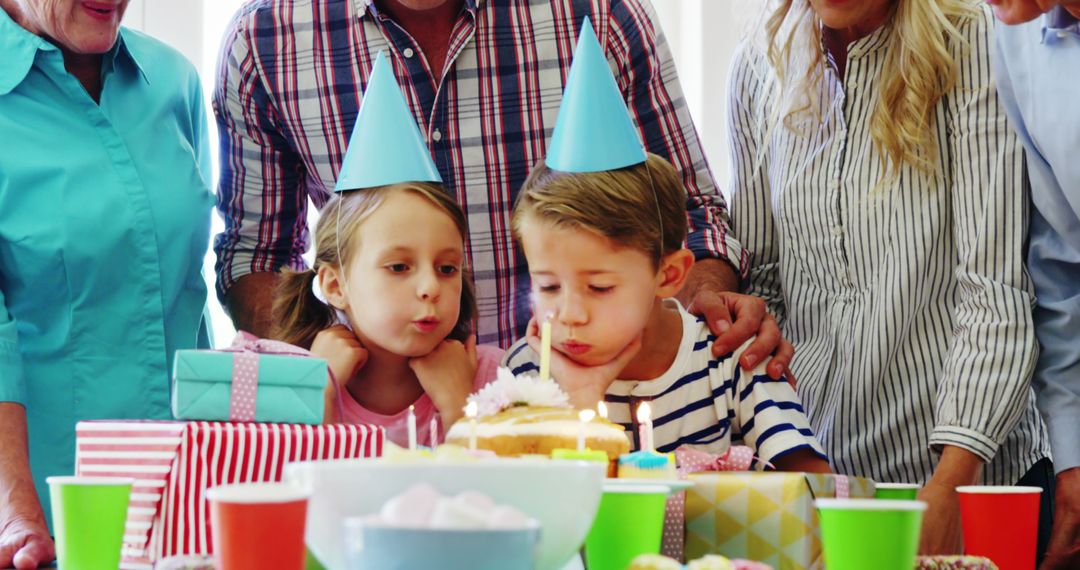 Children Blowing Out Birthday Candles Surrounded by Family Celebration - Free Images, Stock Photos and Pictures on Pikwizard.com