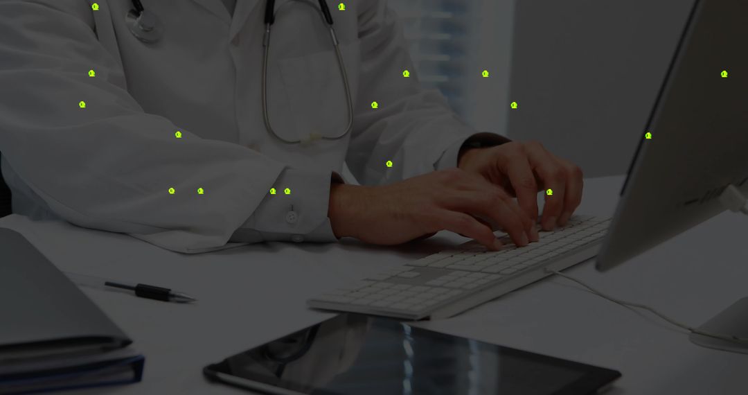 Doctor Typing on Computer in Medical Office with Work Essentials