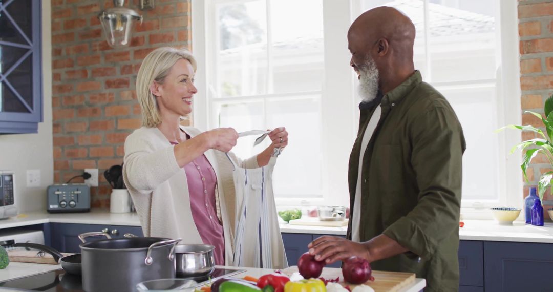 Joyful Couple Preparing Meal Together in Cozy Kitchen Setting