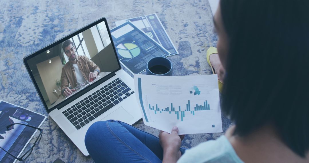 Woman Holding Document While Having Video Call with Data Infographic