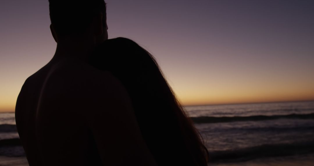 Couple Embracing While Watching Sunset by Ocean - Free Images, Stock Photos and Pictures on Pikwizard.com