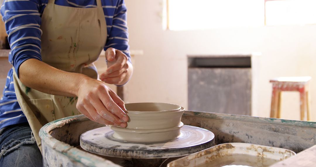 Woman Sculpting Pottery on Wheel in Bright Studio - Free Images, Stock Photos and Pictures on Pikwizard.com