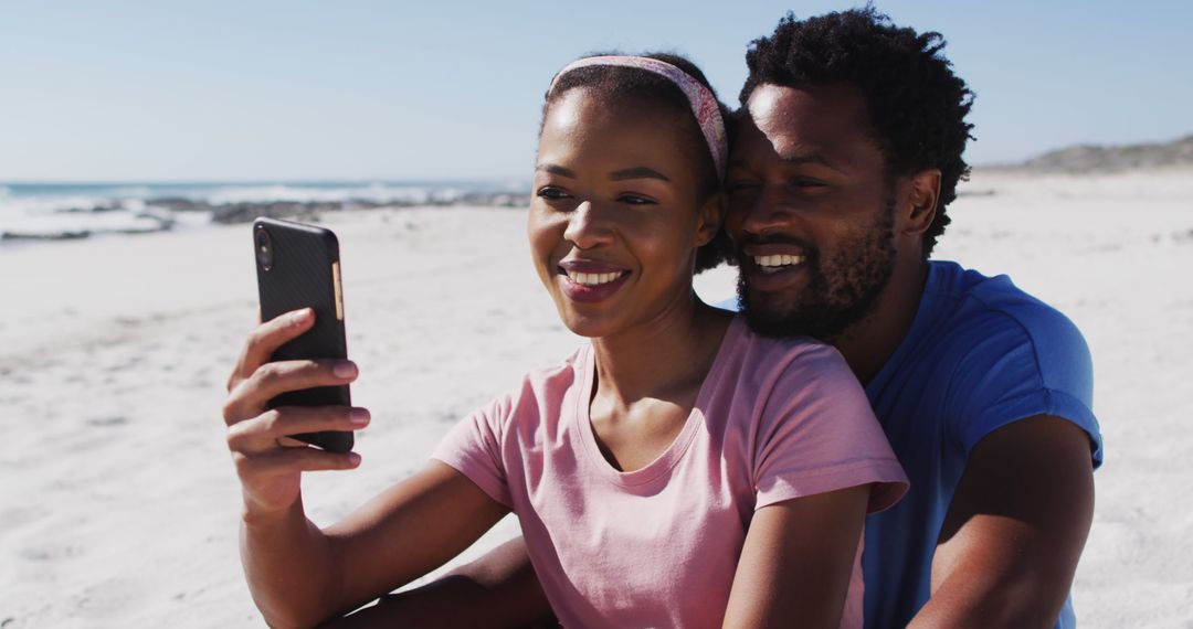 African american couple smiling taking selfie with smartphone on the beach - Free Images, Stock Photos and Pictures on Pikwizard.com